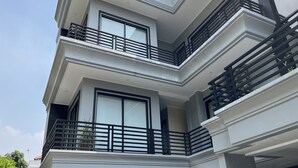 A multi-story building with balconies and large windows. - TOS Guest House By Zuzu (Jakarta)