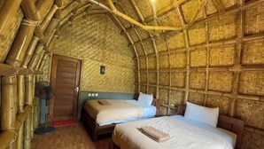 A room with two beds, a wooden door, and a fan. - Villa Bambu Rinjani & Restaurant (Bayan)