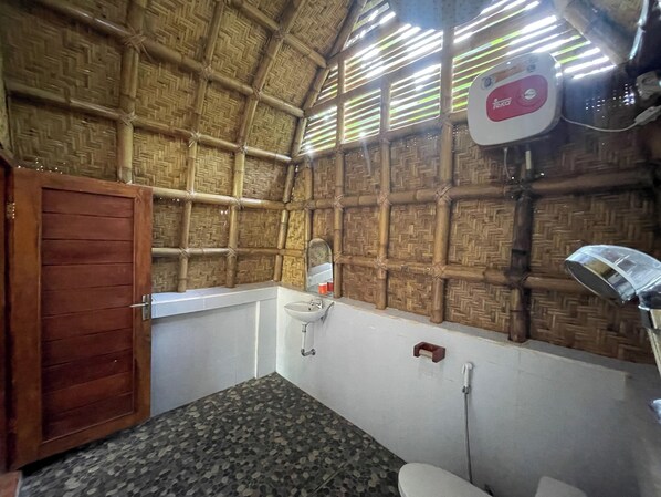 Une pièce avec un plafond en bambou, une porte en bois, un lavabo et des toilettes.