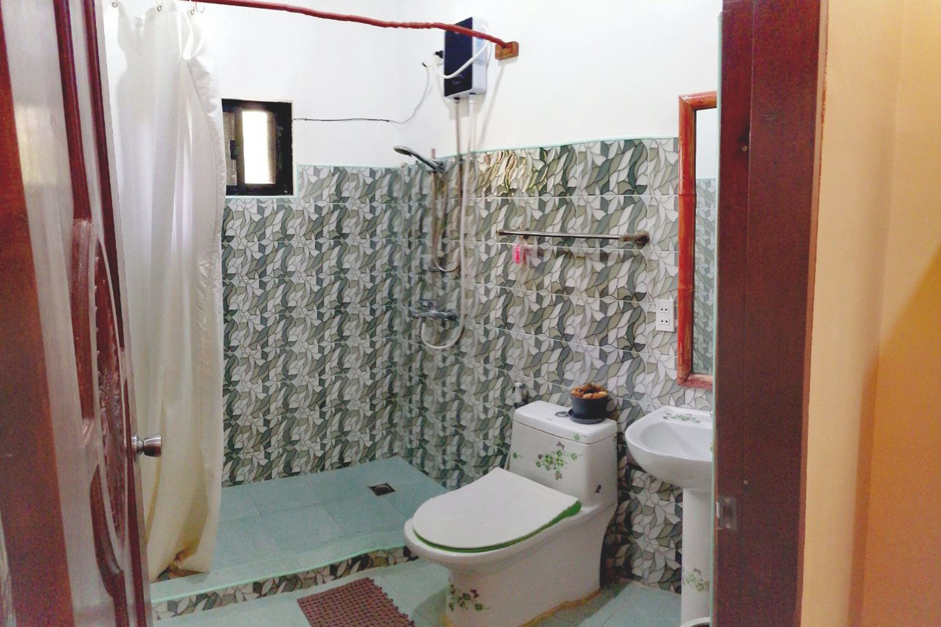 Un baño pequeño con inodoro, lavamanos y ducha.