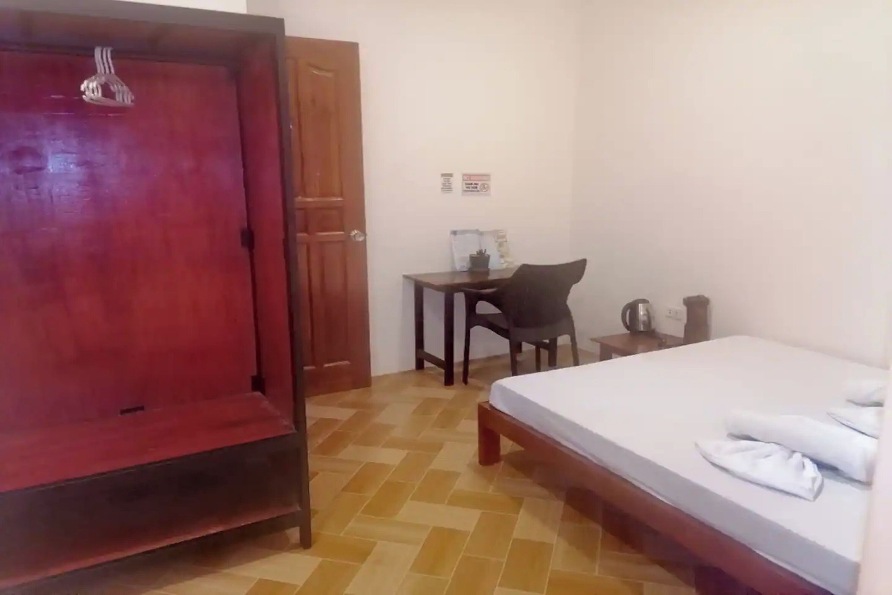 A room with a bed, a desk, a chair, and a wardrobe.
