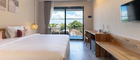 A modern hotel room with a large bed, a desk, and a TV.