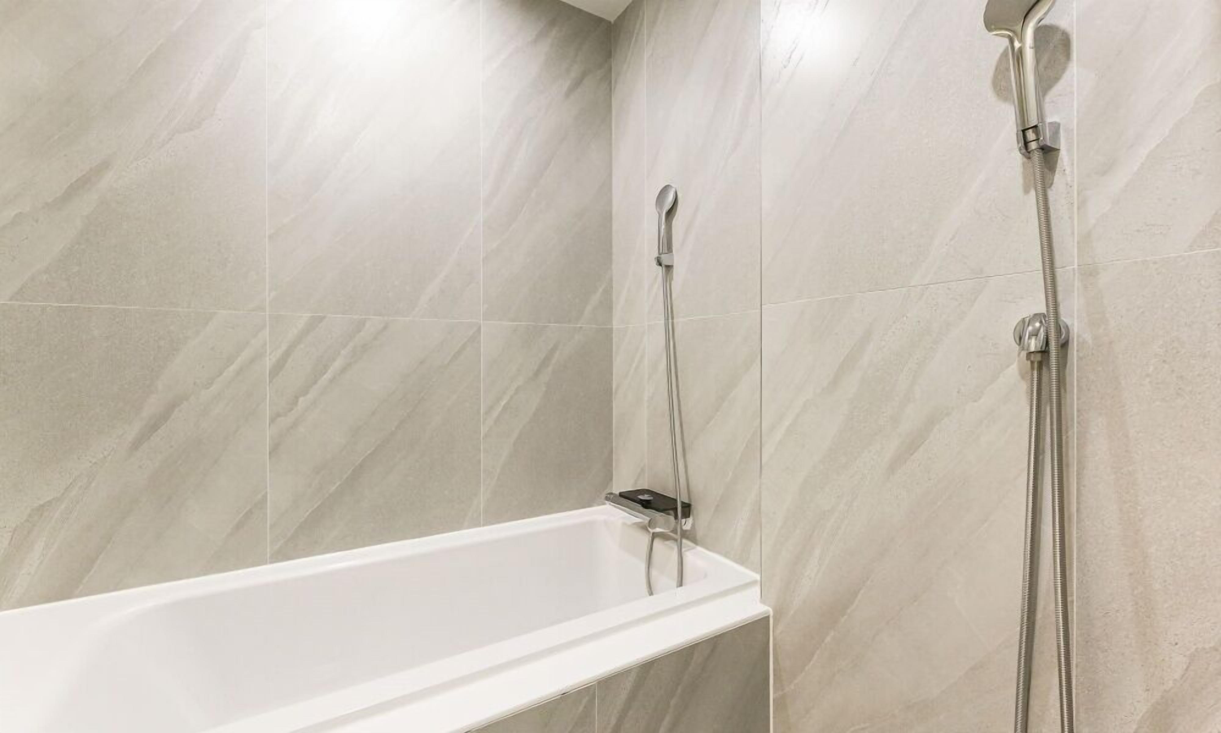 A modern bathroom with a bathtub and a shower.