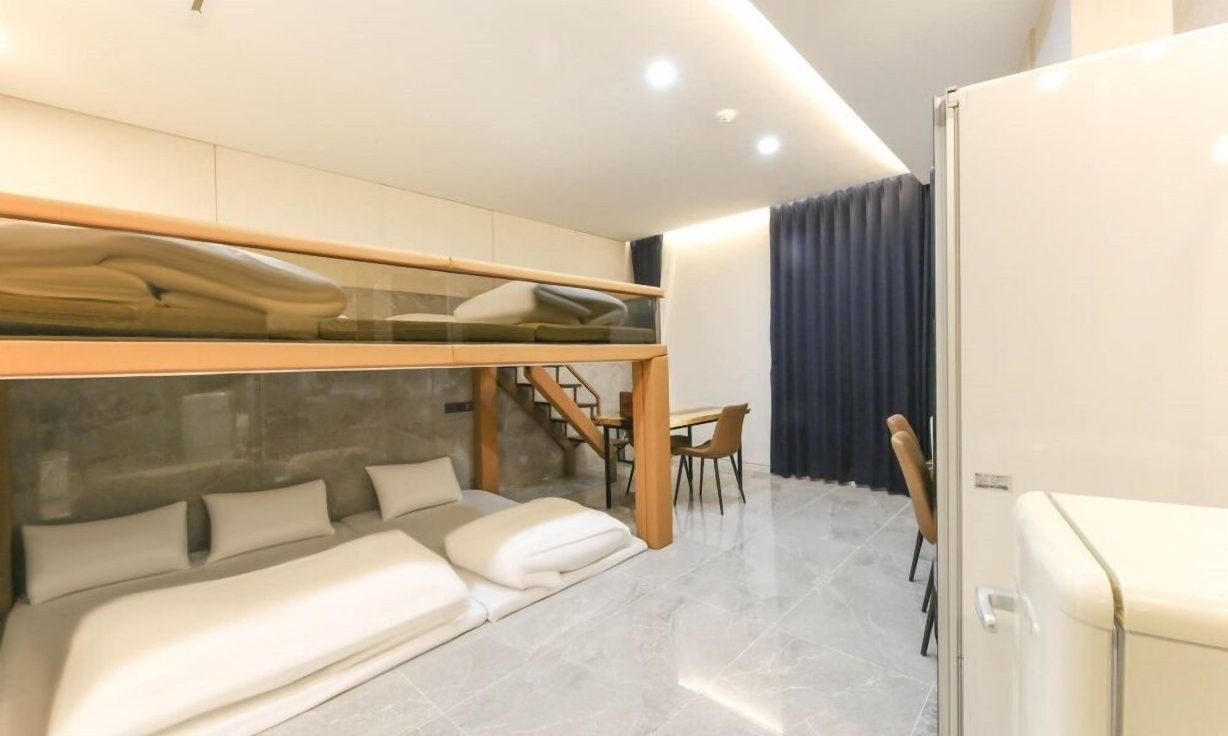 Una habitación de hotel moderna con una cama litera, un escritorio y una silla.