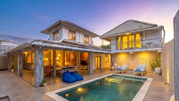 A two-story house with a swimming pool, outdoor seating, and a well-lit patio area. - Villa Bella Vista by Pertama Stay (Seminyak)