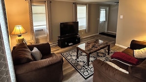 A living room with two brown sofas, a coffee table, and a flat-screen TV. - Cozy, Clean, Convenient and Spacious 3-bedroom apartment in beautiful Clayton. (Clayton)