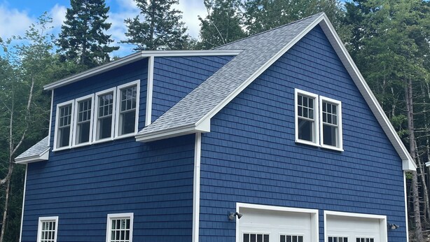 A two-story house with a gabled roof, white trim, and a garage. - Blue Hill in the Woods (Blue Hill)