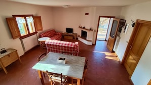 Una sala de estar acogedora con un sofá, una mesa de comedor y una chimenea.