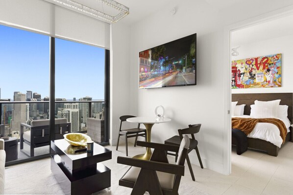 Ein modernes Hotelzimmer mit Balkon, Essbereich und Bett.
