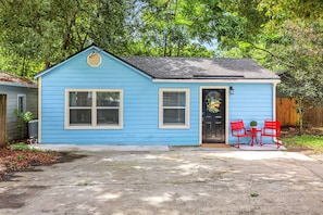 A small blue house with a front porch, two windows, and a door.