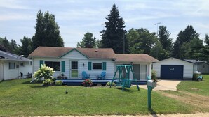 A single-story house with a front porch, a swing set, and a garage.