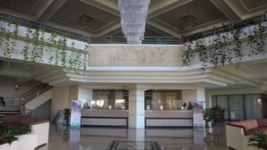 A spacious lobby with a grand chandelier, a reception desk, and a staircase. - Queen Garden Hotel by Salak Hospitality (Baturaden)