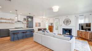 A modern kitchen with a central island, bar stools, and pendant lighting. - Pool & Vibes, Relaxing and Fun! (Austin)