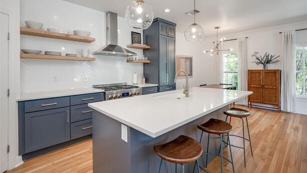 A modern kitchen with a central island, bar stools, and pendant lighting. - Pool & Vibes, Relaxing and Fun! (Austin)