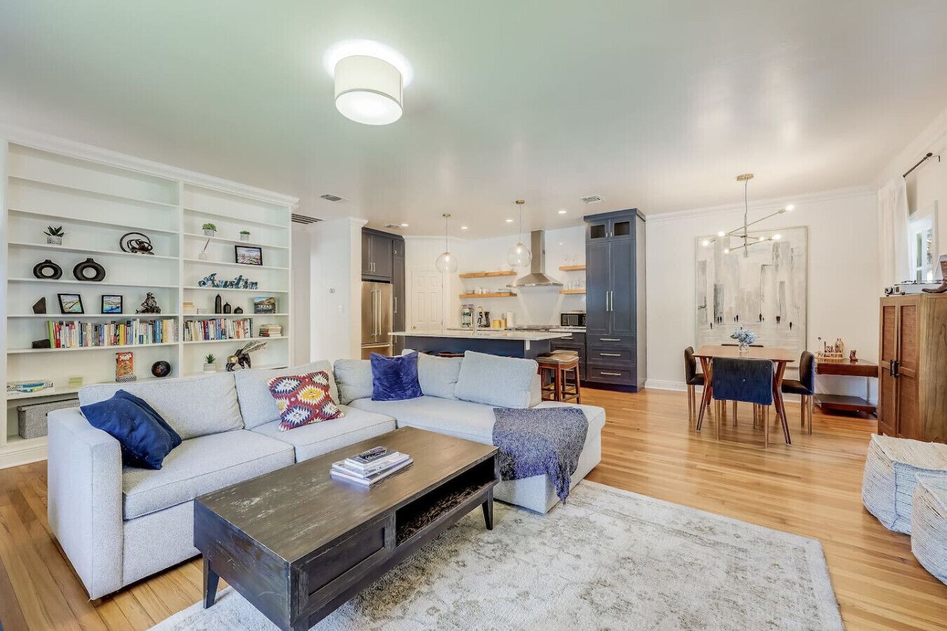 A modern living room with a sofa, coffee table, and bookshelves.