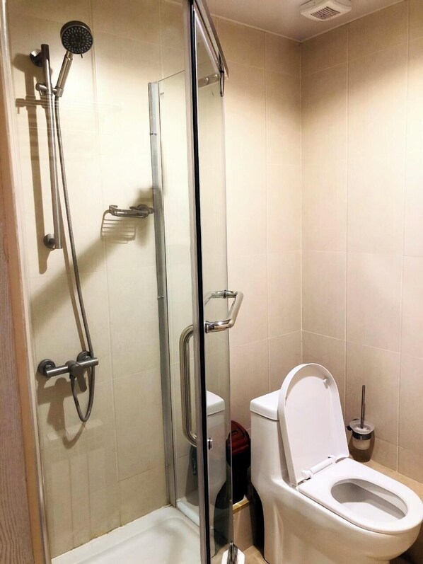 Un baño moderno con ducha envuelta en vidrio, inodoro y bidé.