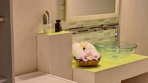 A compact laundry room with a Samsung washing machine, a glass sink, and a small cactus on the counter. - Le Jasmyna (Sans Pareil)