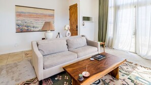 A modern living room with a sofa, coffee table, and artwork on the wall.