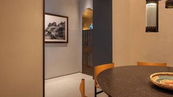 Un comedor con una mesa redonda, sillas, una fotografía enmarcada en la pared y un jarrón decorativo.