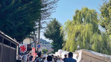 A bustling market scene with people walking and vendors displaying goods.