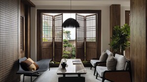 A modern interior with a wooden partition, a table with a vase, and two sofas. - LA MAISON . View Resort (Lijiang)