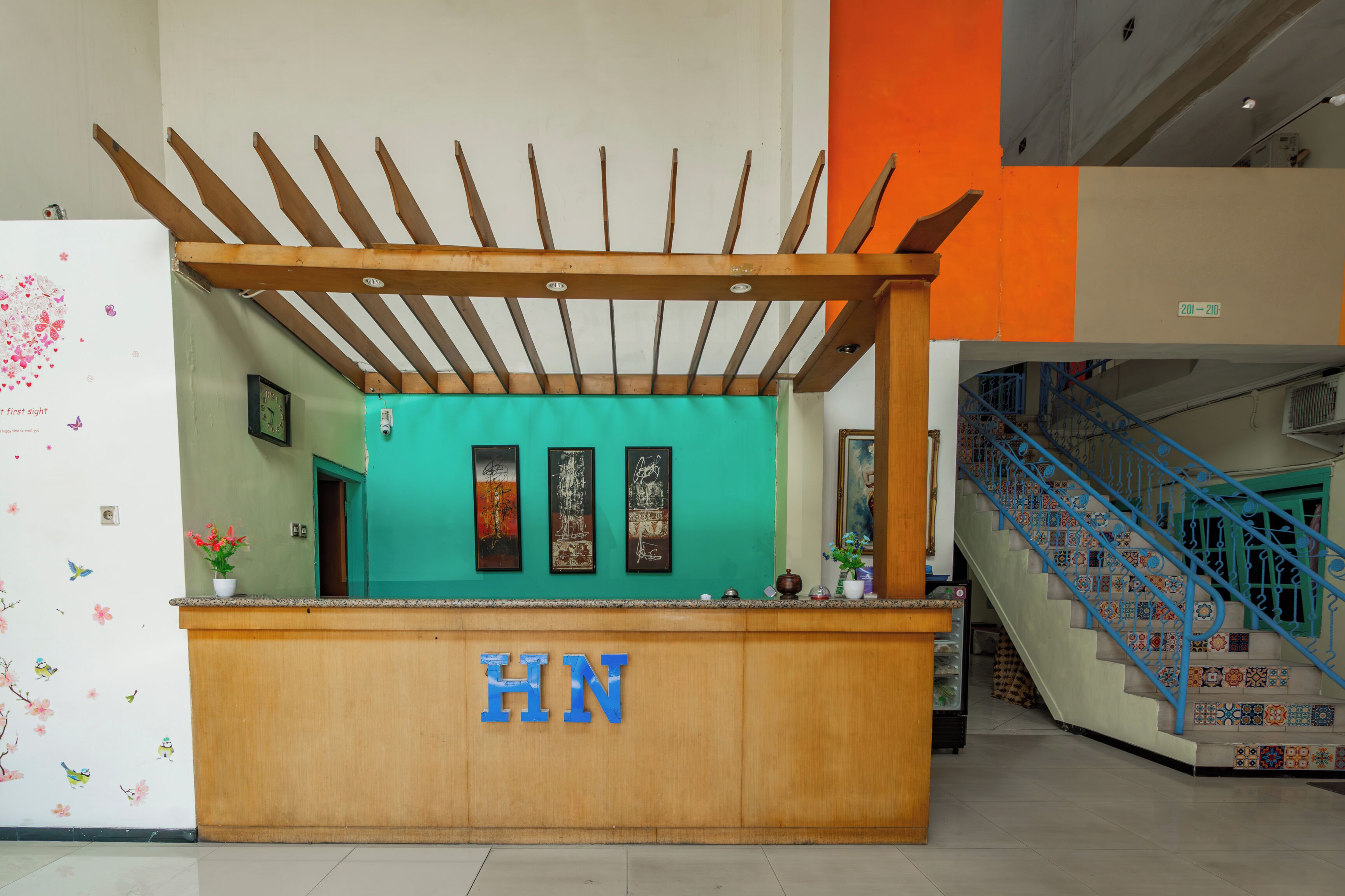 A reception desk with a wooden counter and a sign reading "HN".