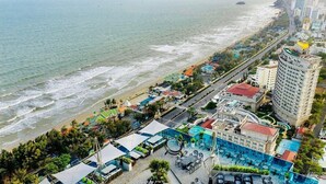 Un hôtel situé sur la côte, doté d’une piscine, d’un accès à la plage et offrant une vue sur l’océan.