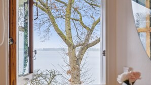 A window with a view of a tree and a body of water. - "Titta" - 10m to the fjord by Interhome (Holbæk)