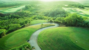 An aerial view of a golf course with winding paths and lush greenery.
