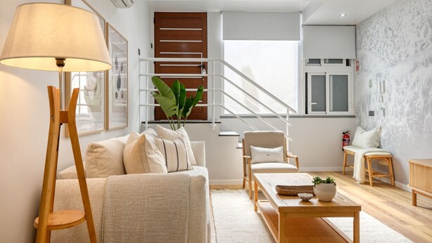 A modern living room with a sofa, armchair, coffee table, and a floor lamp. - Seashell, a Home in Madeira (Machico)