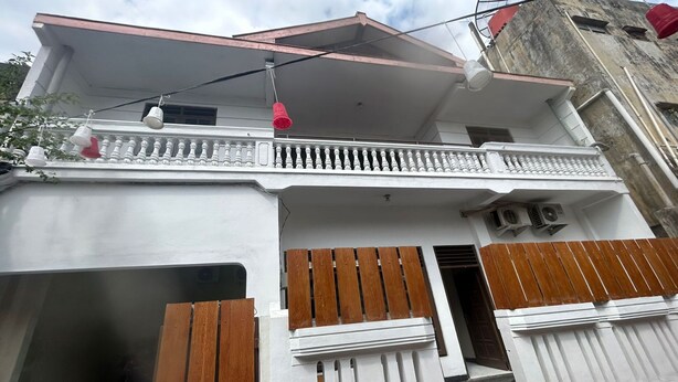 Un edificio a due piani con un balcone e un cancello in legno.