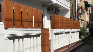 Un muro bianco con una recinzione di legno e una porta bianca.