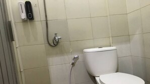Un bagno con il water, una doccia e un asciugamani ad aria.