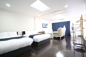 A hotel room with two beds, a desk, a chair, and a TV. - Ideal Yuuhigaoka (Osaka)