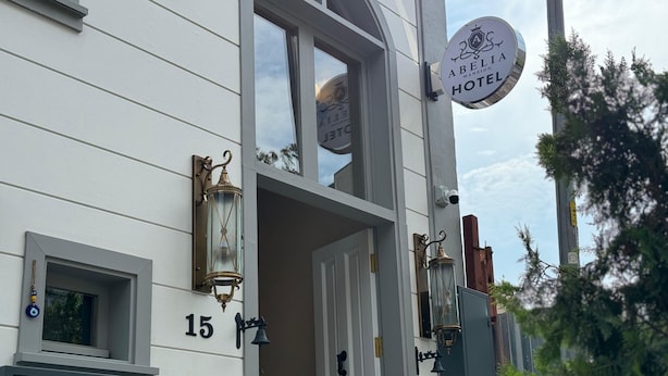 A hotel entrance with a sign reading "Abelia Mansion Hotel," a number "15" on the wall, and a door with a bell. - Abelia Mansion Hotel (Istanbul)