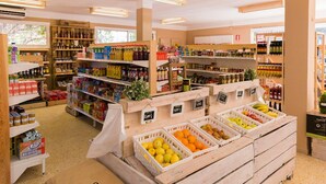 A grocery store with various products on shelves and in bins, including fruits and beverages. - Home Stay Steps from Sand (Cambrils)