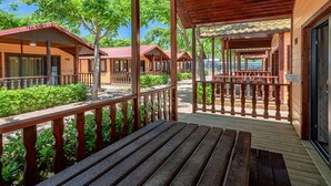A wooden cabin-style hotel with a covered porch and wooden deck. - Chalet in Blanes near the Beach & Pool (Blanes)