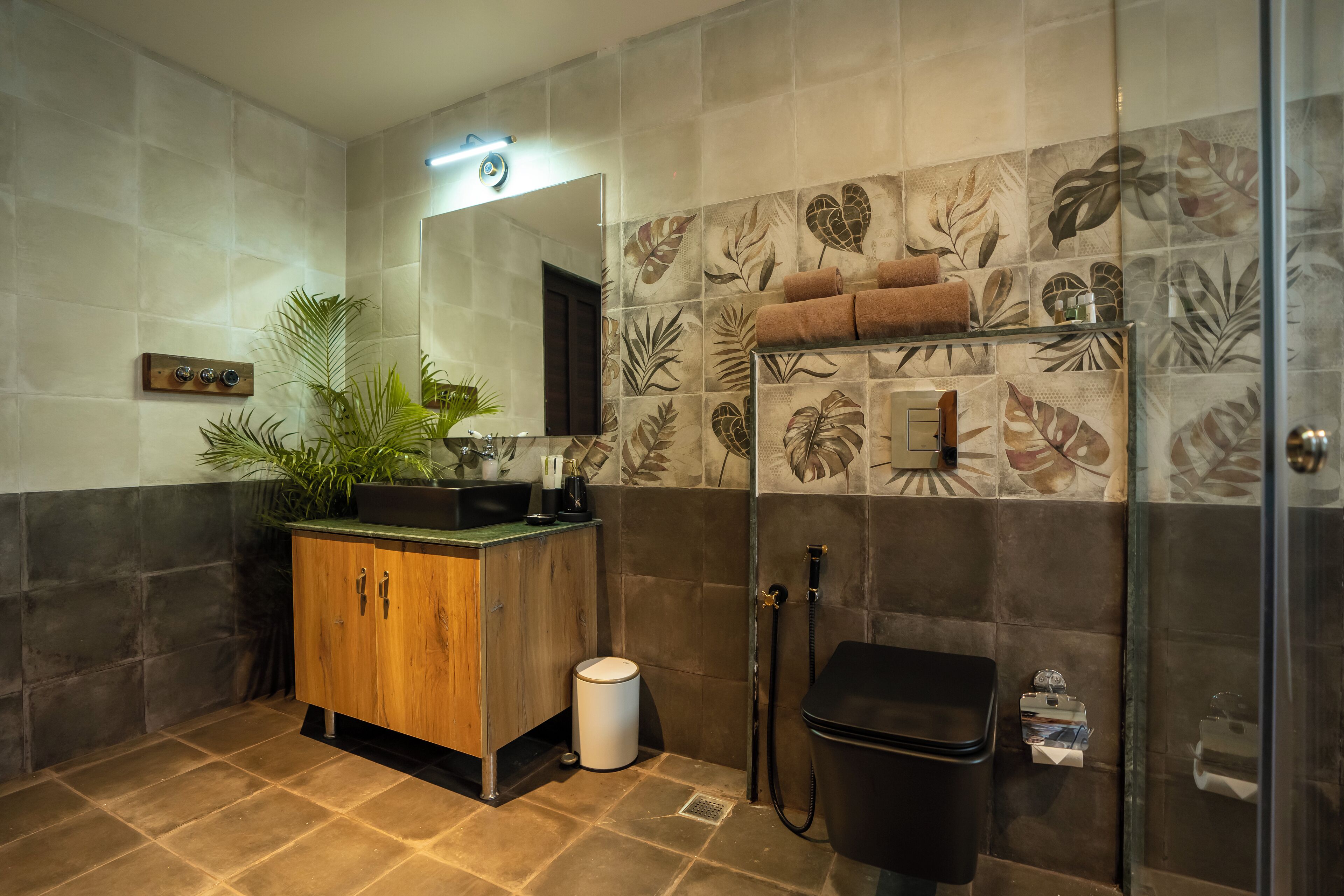 Un baño con tocador de madera, espejo, ducha y azulejos decorativos.
