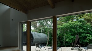 A modern interior with a large sliding glass door leading to an outdoor deck. - SANGO (Otaru)