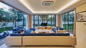 A modern living room with a large sectional sofa, a coffee table, and a flat-screen TV. - Danang Private Swimming Pool Villa (Da Nang)