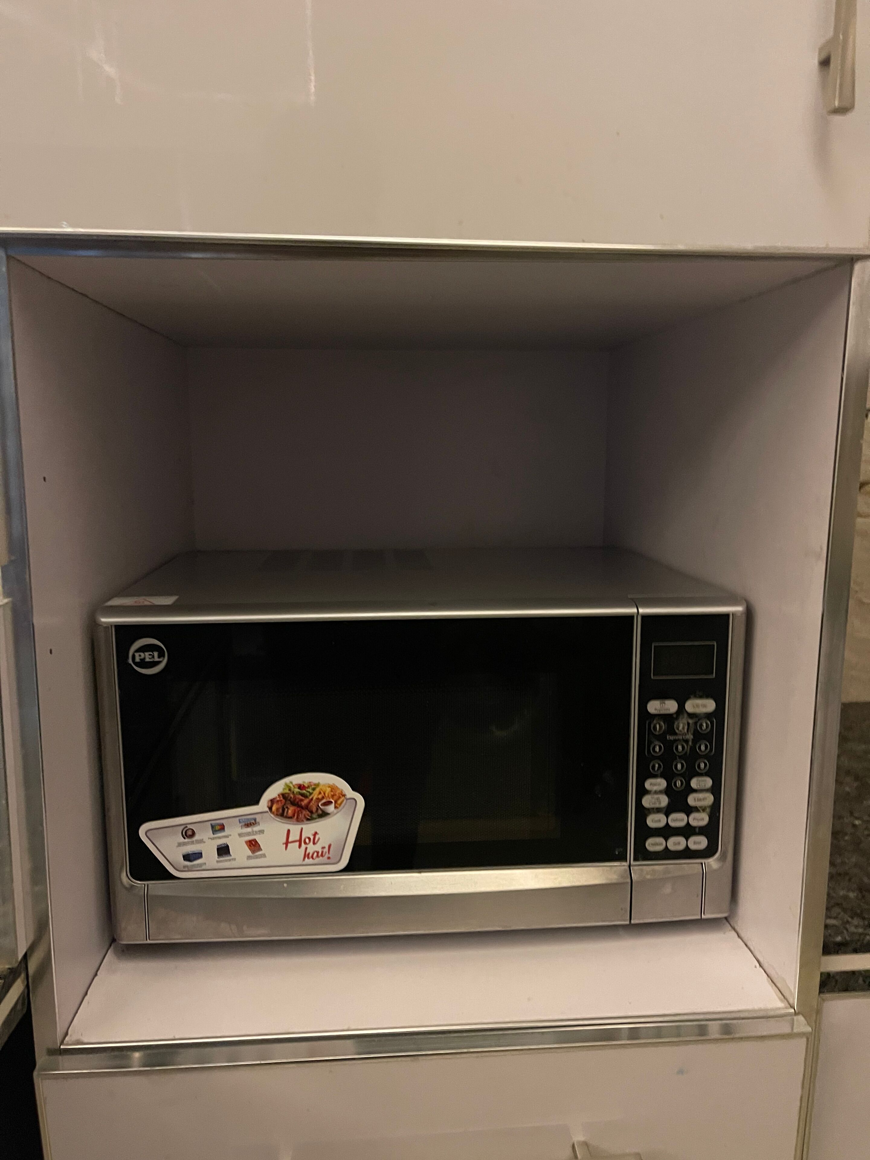 Un four à micro-ondes dans un meuble blanc.