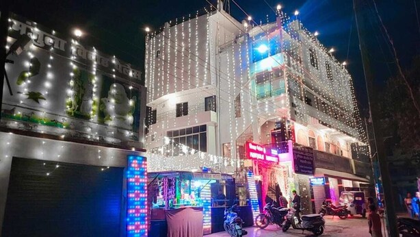 A building with multiple floors, decorated with string lights. - Hotel Nilay By GRB (Kahalgaon)