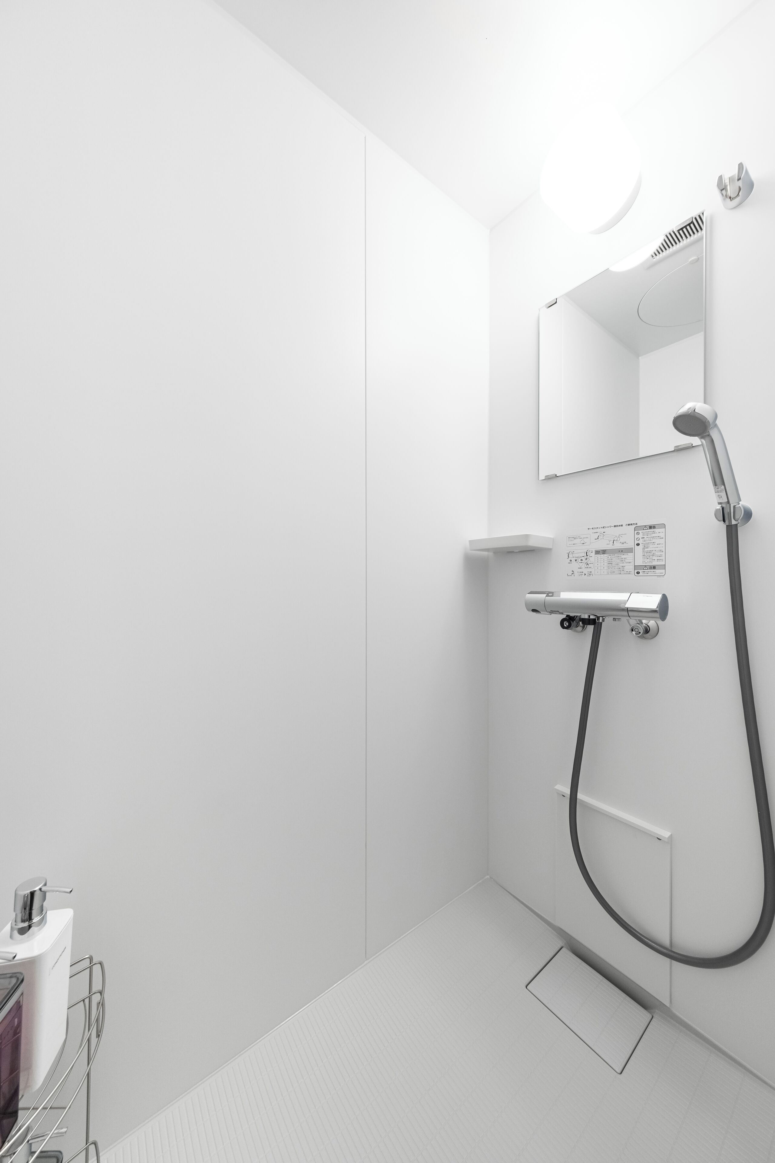 Un baño moderno con ducha, espejo y lavabo.