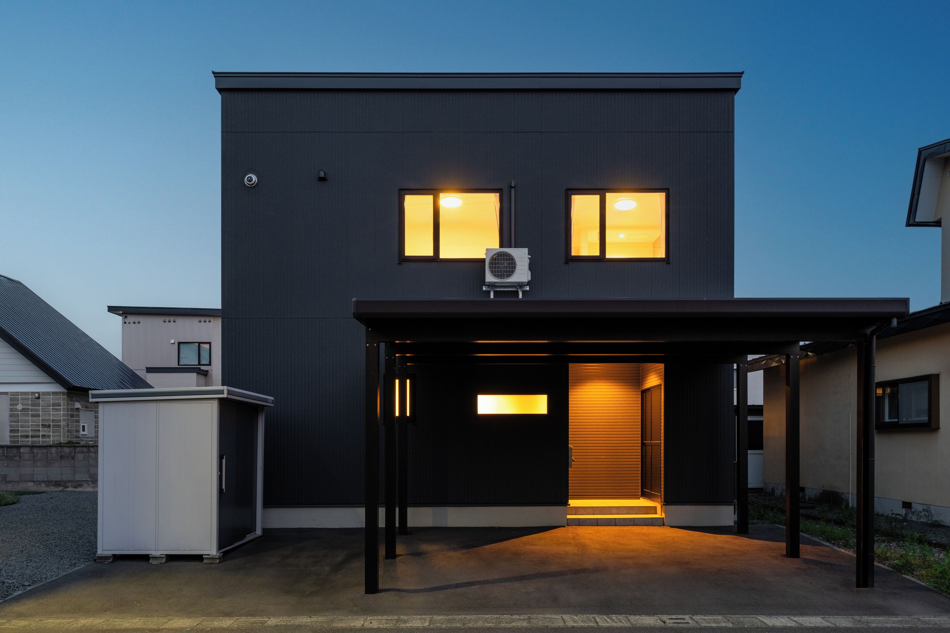A modern two-story building with a covered entrance and a small attached garage.