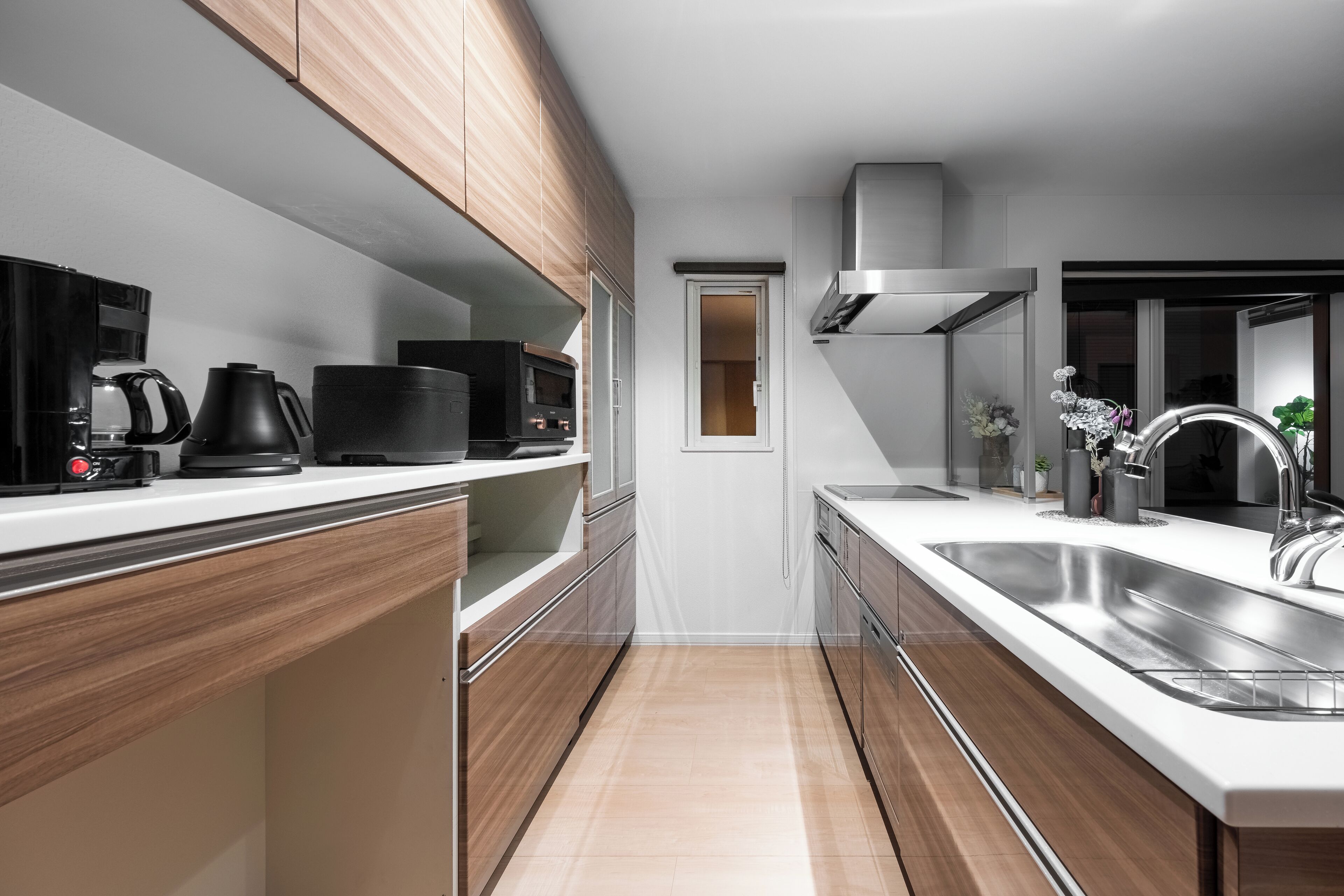 A modern kitchen with wooden cabinets, stainless steel appliances, and a large sink.