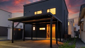 Ein modernes, zweistöckiges Gebäude mit überdachter Eingangspartei und Garage.