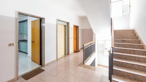 A modern interior with a staircase, a kitchen visible through an open door, and a welcome mat on the floor. - 4146 Giò House by Barbarhouse (Gallipoli)