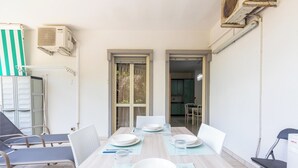 A dining area with a table set for four, chairs, and a view into the kitchen. - 4146 Giò House by Barbarhouse (Gallipoli)