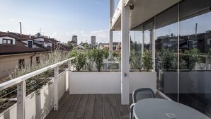 A balcony with a view of the city, a table, and chairs. - Palazzo Vittoria Hotel Milano (Milan)