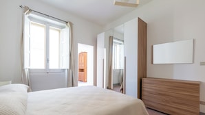 A bedroom with a bed, a wooden dresser, a mirror, and a window with curtains. - 4086 Maison Malù by Barbarhouse (Nardò)